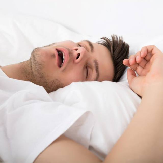 Young man snoring in bed