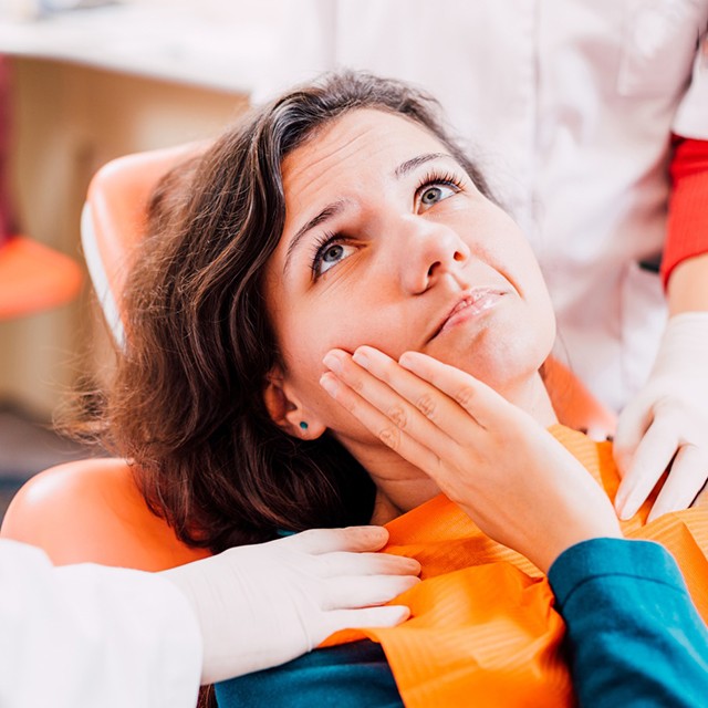 Woman with mouth pain, looking at dentist