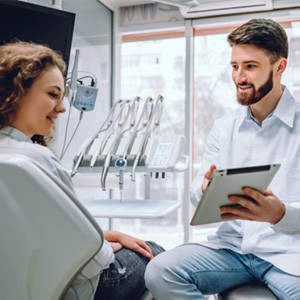 Dentist and patient looking at tablet together