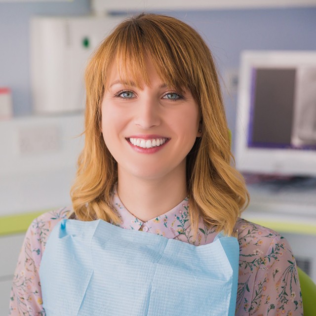 Dental implant patient smiling in treatment chair