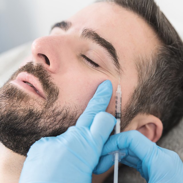 Man relaxing while receiving BOTOX® injection near eye