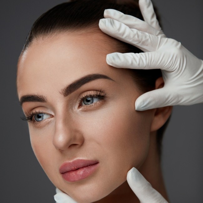 Oral surgeon examining patient after dermal filler treatment