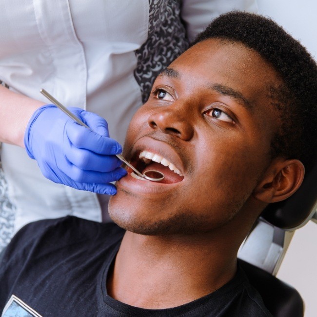 Patient receiving dental checkup to prevent dental emergencies