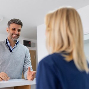 Dental patient laughing with front desk team member