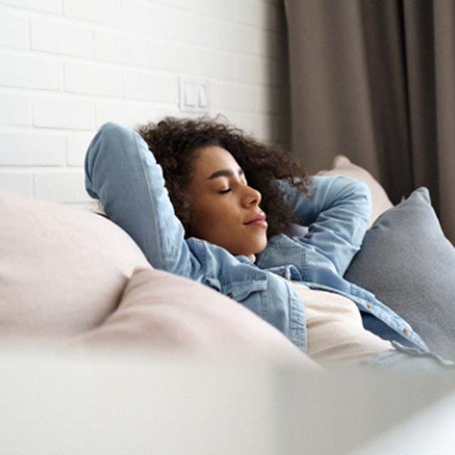 Woman resting comfortably at home after tooth extraction