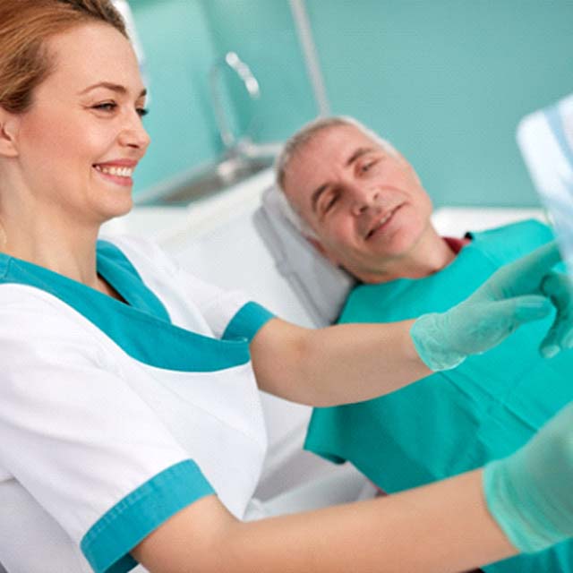 Middle-aged man learning about his candidacy for implant dentures