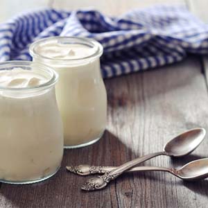 Two glass cups filled with yogurt sitting on tabletop