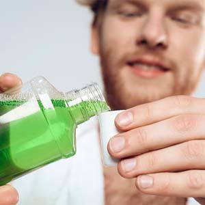 Man using mouthwash as part of his post-op oral hygiene routine