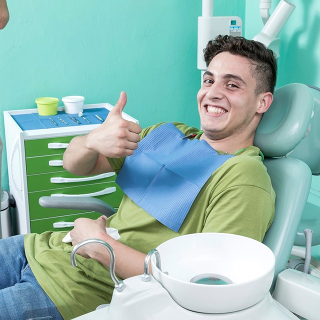 Happy dental patient giving thumbs up