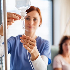 Oral surgery team member preparing IV drip