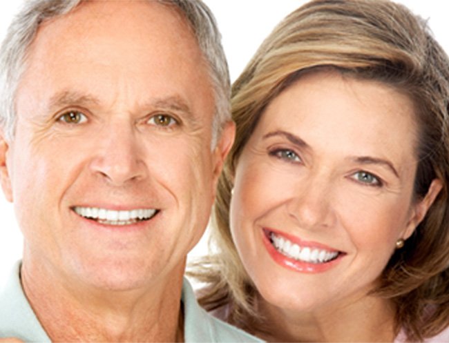 Portrait of mature couple with dental implants against white background