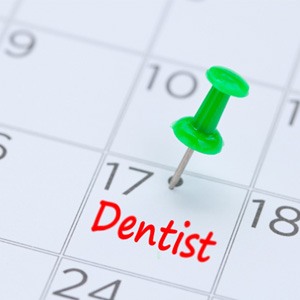 Dental appointment marked on calendar with green thumbtack