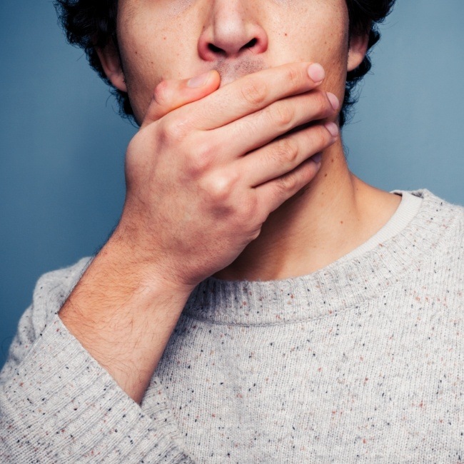 Man covering his mouth before facial trauma repair