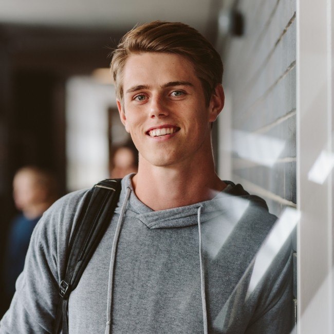 Young man sharing healthy smile after corrective orthodontic surgery