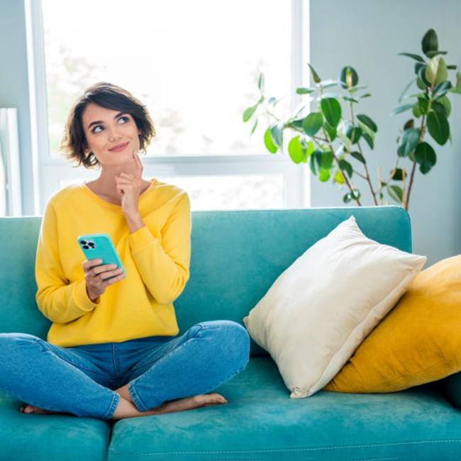 Woman sitting on sofa with curious expression on her face