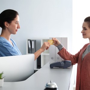 Patient using card to pay for dental treatment