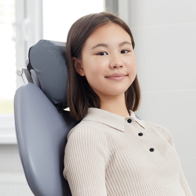 Young woman smiling in dental chair before wisdom tooth extraction