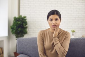 Woman with hand on mouth, thinking about wisdom teeth extractions