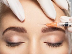Close-up of woman getting BOTOX injection between her eyes