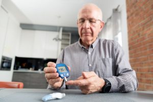 Man checking blood sugar, concerned about sleep apnea