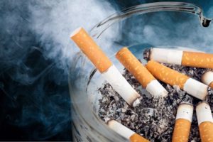 Cigarettes, a danger to dental implants, sitting in ashtray