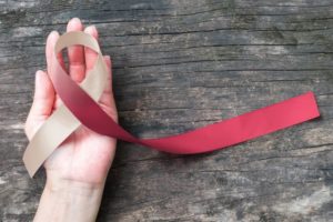 Oral cancer awareness ribbon resting in palm of hand