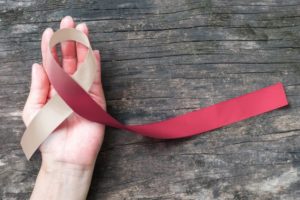 Oral cancer awareness ribbon resting in palm of hand