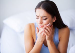 Woman experiencing sensitivity in a dental implant