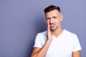 Man with mouth pain, concerned about a failed dental implant