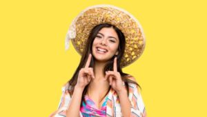 Woman in summer clothes, pointing at her smile