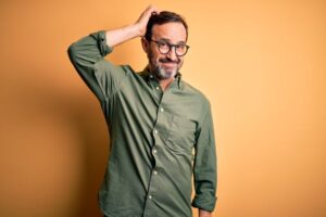 Middle-aged man scratching his head