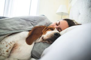 Woman sleeping with her dog