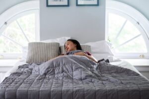 Woman sleeping peacefully under a weighted blanket