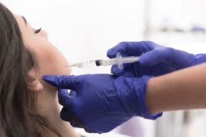 Woman receiving BOTOX injection near her jaw 