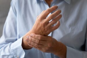 Woman touching her wrist, experiencing the pain of rheumatoid arthritis 