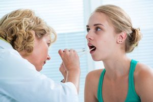 Doctor looking at patient’s tonsils