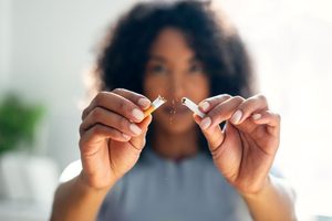 Woman breaking a cigarette in half 